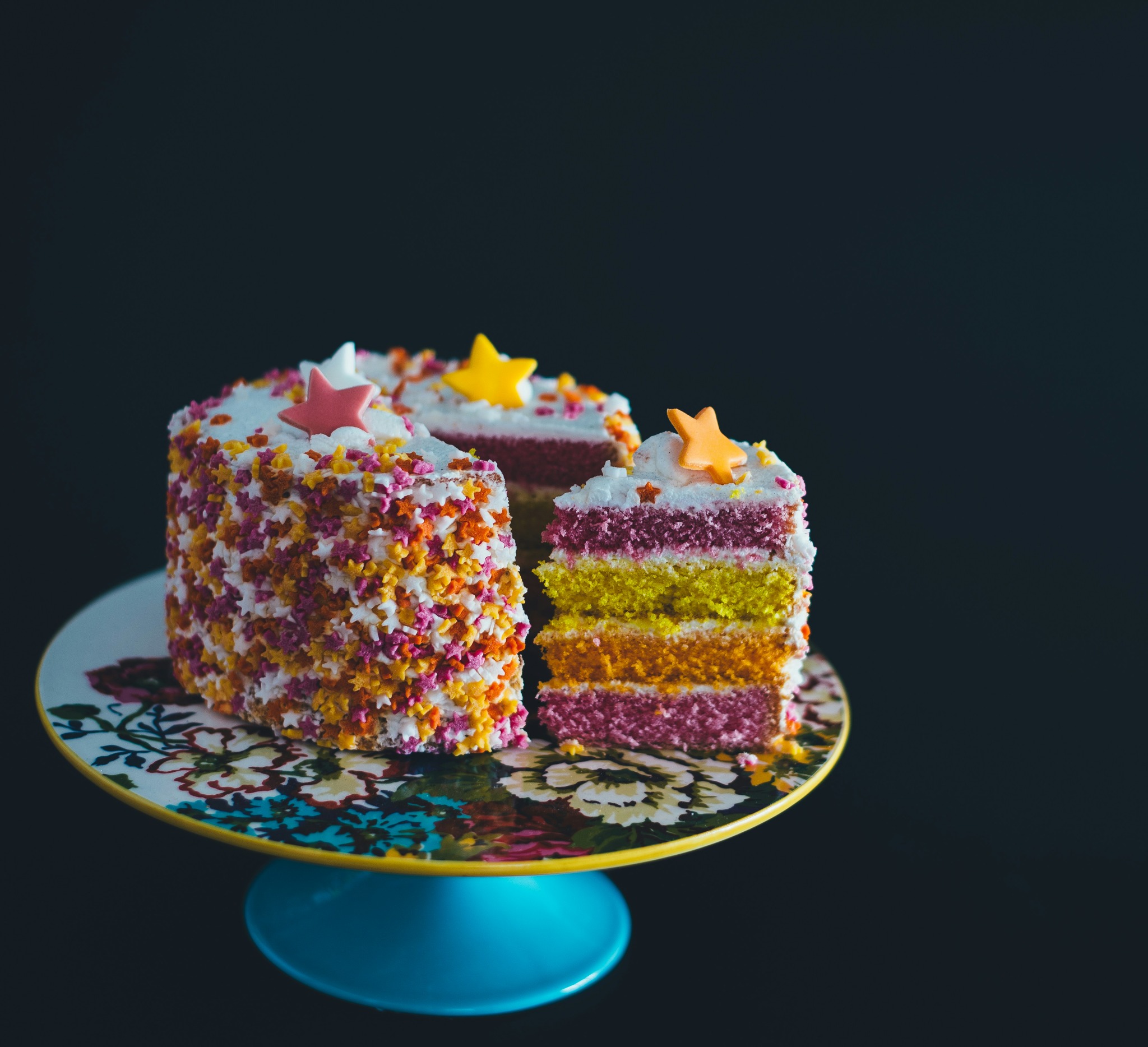 Pastel de celebración en tonos vivos sobre fondo oscuro